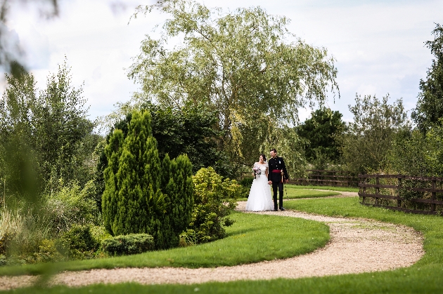 Bride and groom walking along a path through the gardens at the Garden at Eden