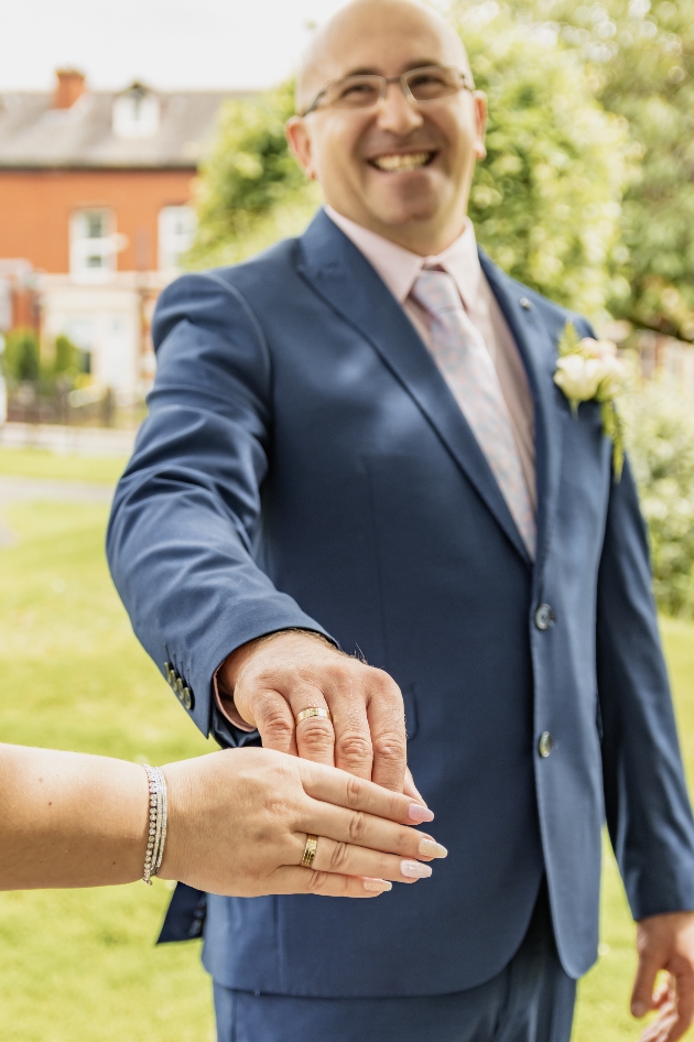 Groom in his big-day suit holding his bride's hand
