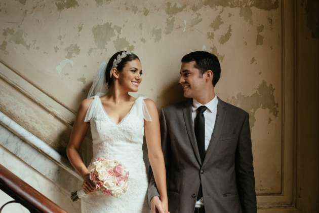 bride and grooms in their wedding attire standing on a stairs in a venue