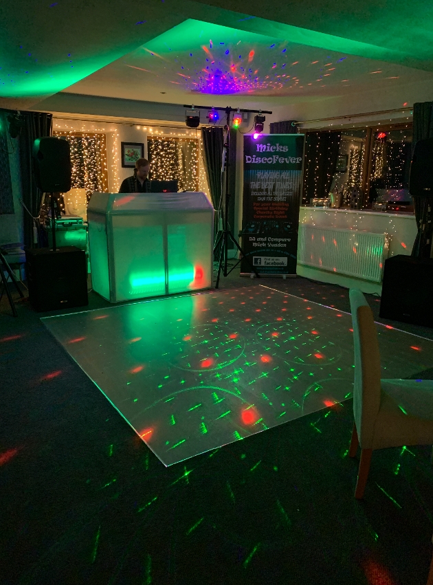DJ desk with fairylight curtains and laser lights