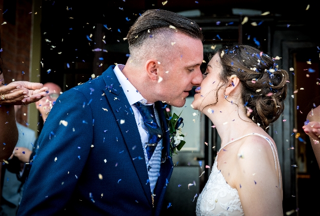Newlyweds kiss under confetti
