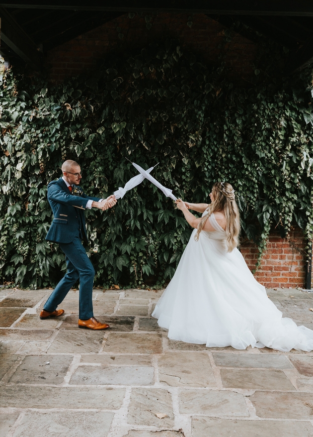 Couple sword fight with umbrellas