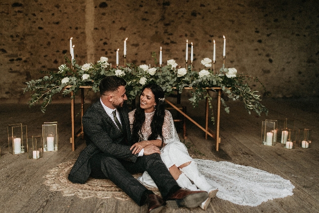 Bride and groom sitting on the floor in a barn