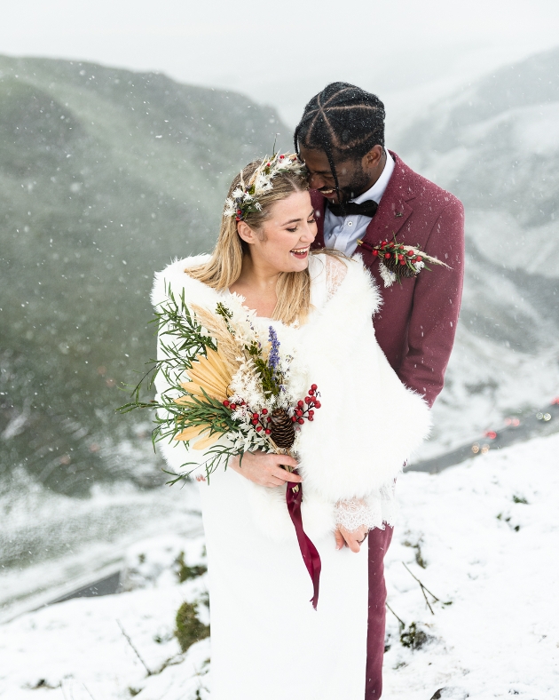 Bride and groom embracing in the snow