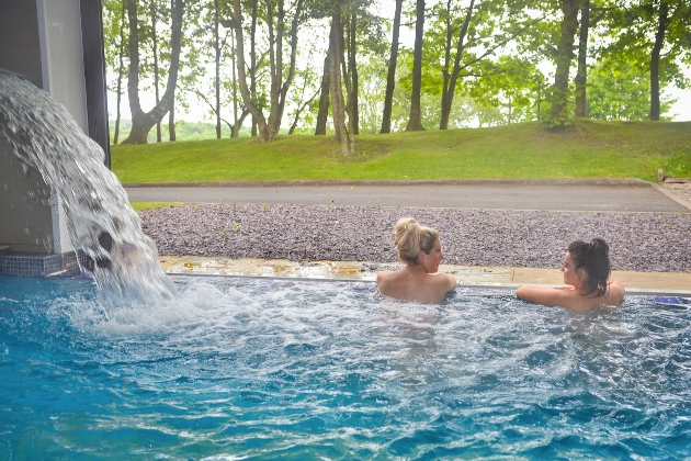 Two women talking in a swimming pool at Mercure Norton Grange Hotel and Spa