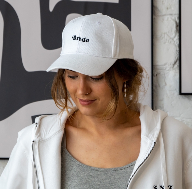 Woman wearing a white hat with the word bride on