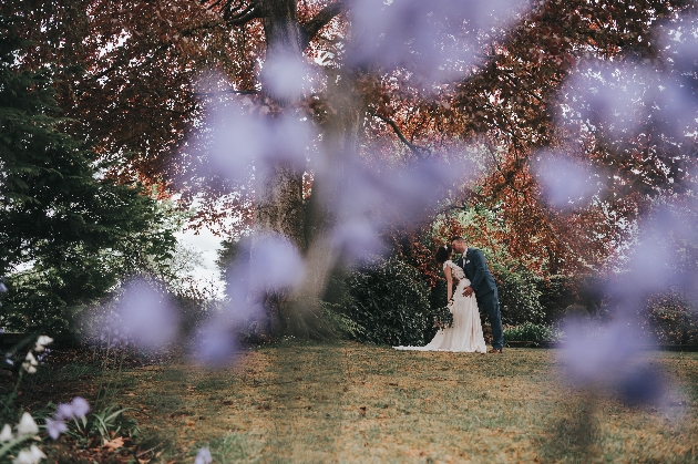 Bride and groom embracing underneath a tree