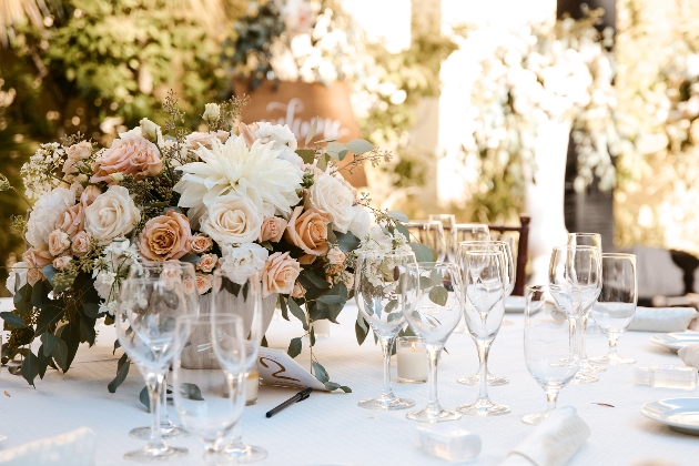 table at reception with flower display in centre peach tones