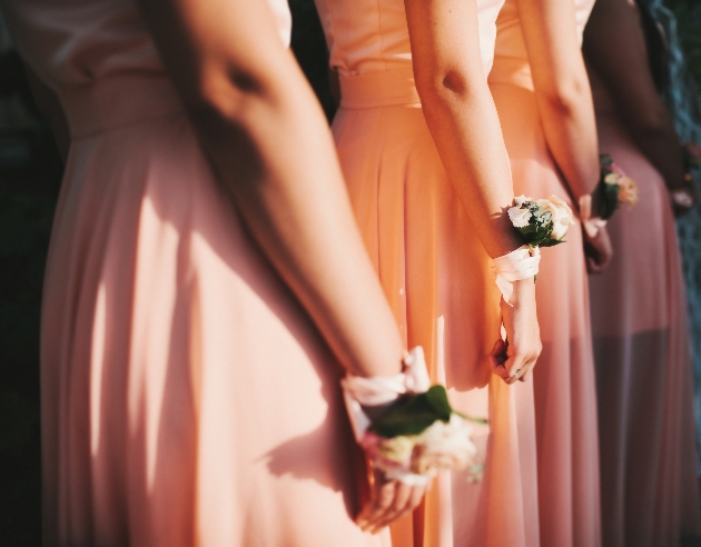 peach bridesmaids' dresses and wrist flowers