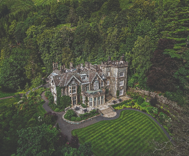 A sky view of a grand mansion nestled in glorious gardens