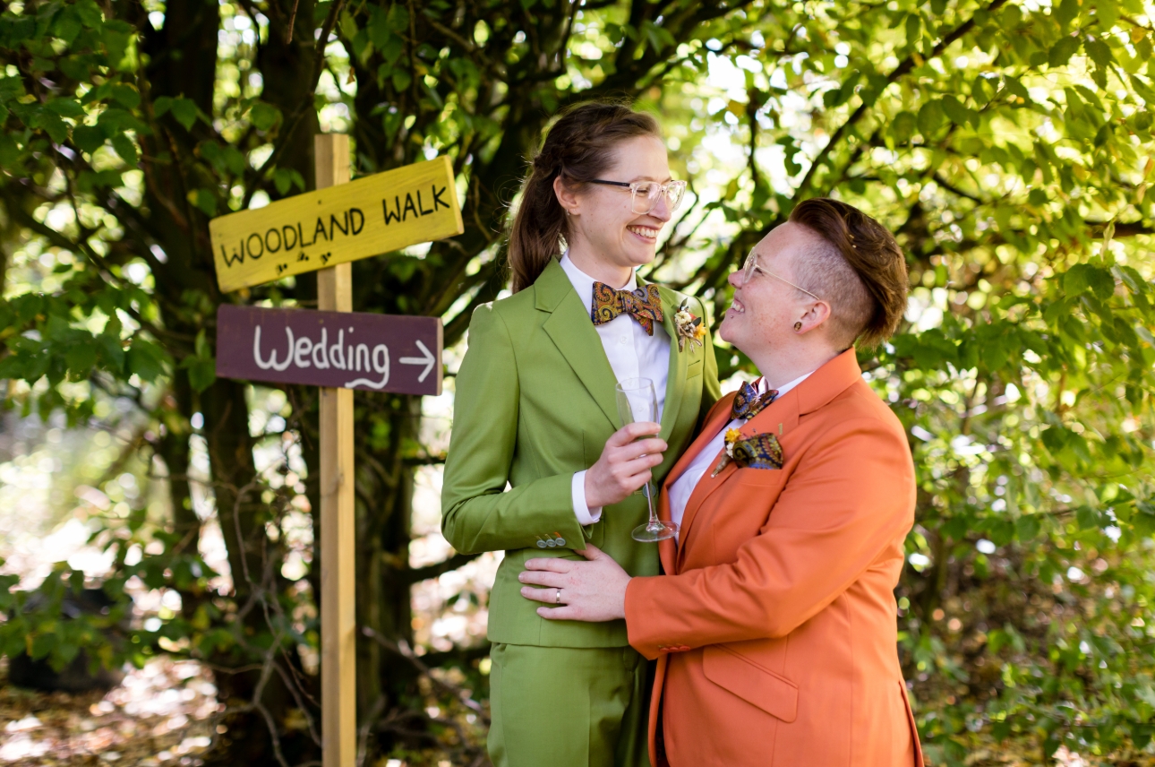 two brides in suits one orange and one green