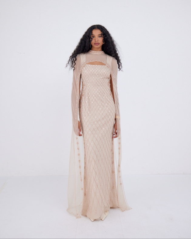 woman posing in long champagne coloured dress with lots of beading 