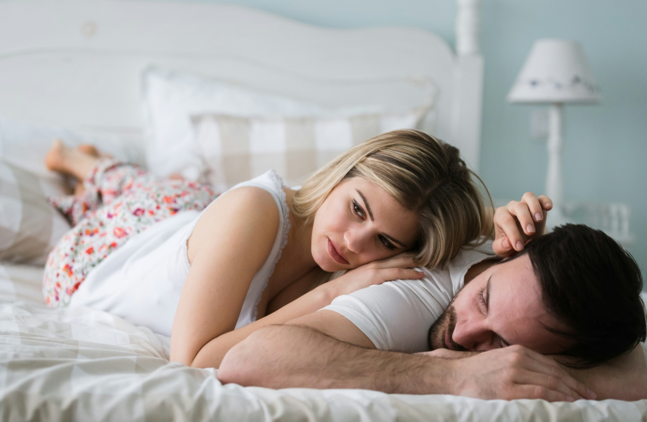couple in bed looking sad