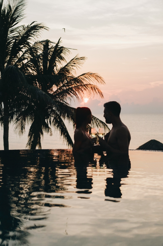 man and woman in a pool at sunset