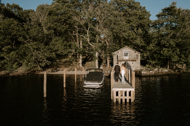 A bride and groom walking on a boat dock