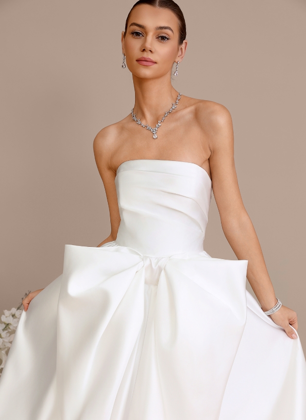 model in strappless duchess satin wedding dress with big bow on front