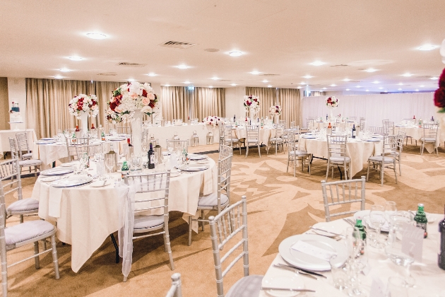 A neutrally decorated room with round tables 